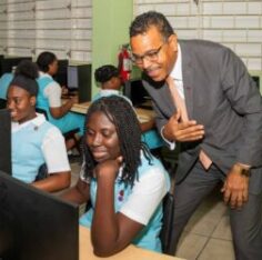 Nigel Holness, managing director, CIBC, observes students at work during a tour of the computer lab at Wolmer’s High School for Girls. Jamaica Observer