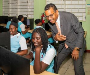 Nigel Holness, managing director, CIBC, observes students at work during a tour of the computer lab at Wolmer’s High School for Girls. Jamaica Observer