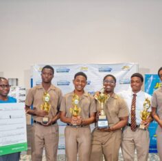 JPS CFO Vernon Douglas presents the first-place cheque to the Wolmer’s Boys debate team. Jamaica Observer