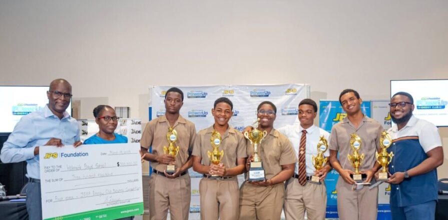 JPS CFO Vernon Douglas presents the first-place cheque to the Wolmer’s Boys debate team. Jamaica Observer