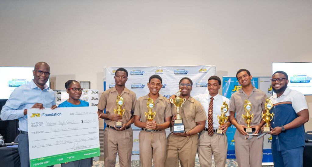 JPS CFO Vernon Douglas presents the first-place cheque to the Wolmer’s Boys debate team. Jamaica Observer