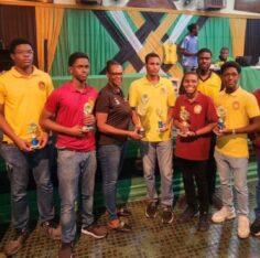 Jamaica Chess Federation secretary Maxine Brown presents the trophy to Wolmer’s Boys captain FM Jaden Shaw. Jamaica Observer