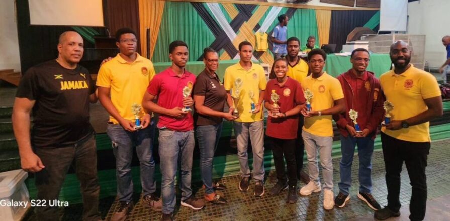 Jamaica Chess Federation secretary Maxine Brown presents the trophy to Wolmer’s Boys captain FM Jaden Shaw. Jamaica Observer