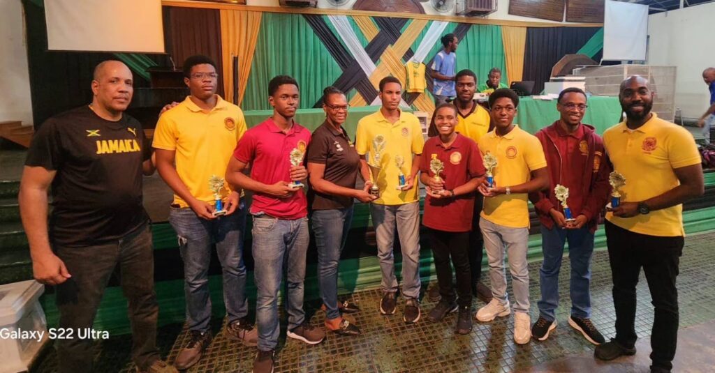 Jamaica Chess Federation secretary Maxine Brown presents the trophy to Wolmer’s Boys captain FM Jaden Shaw. Jamaica Observer