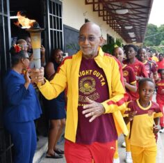 Douglas Orane takes the torch to Principal Dwight Pennycooke on Wolmer’s Day 2026. Photo: Garfield Robinson / Jamaica Observer