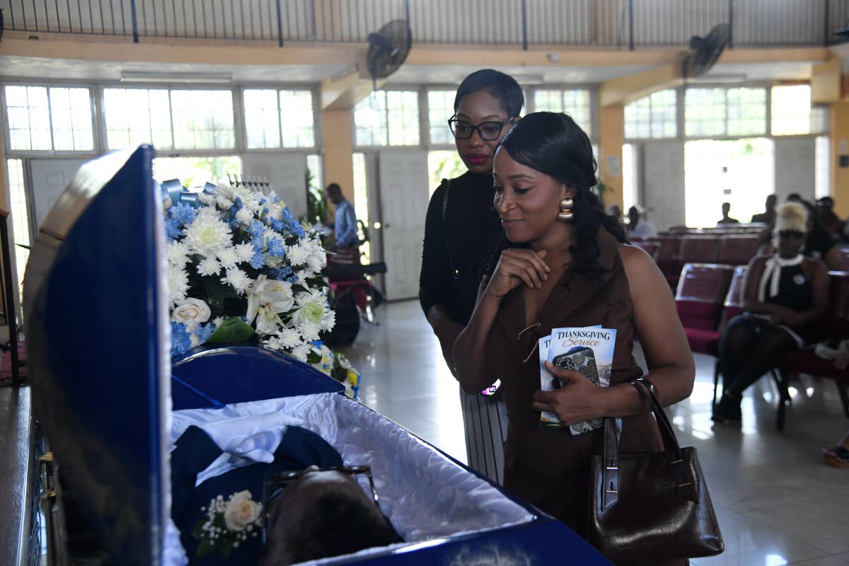 Kimone Francis (left), vice president of the Press Association of Jamaica, and Taneisha Mundle, senior journalist at the RJRGLEANER Communications Group, view the body of late veteran journalist Balford Henry before the start of his funeral ceremony at the Kencot Christian Fellowship Church in St Andrew on Saturday. Photo - Antoine Lodge Jamaica Gleaner, October 10, 2026.