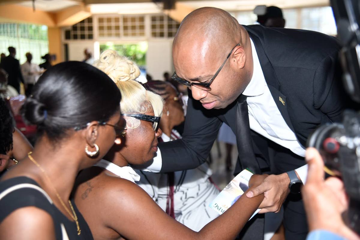 State Minister in the Ministry of Industry, Investment and Commerce Delano Franklin consoles Shai-Ann Henry, daughter of late veteran journalist Balford Henry, before the start of the funeral service on Saturday. Photo - Antoine Lodge Jamaica Gleaner, October 10, 2026.