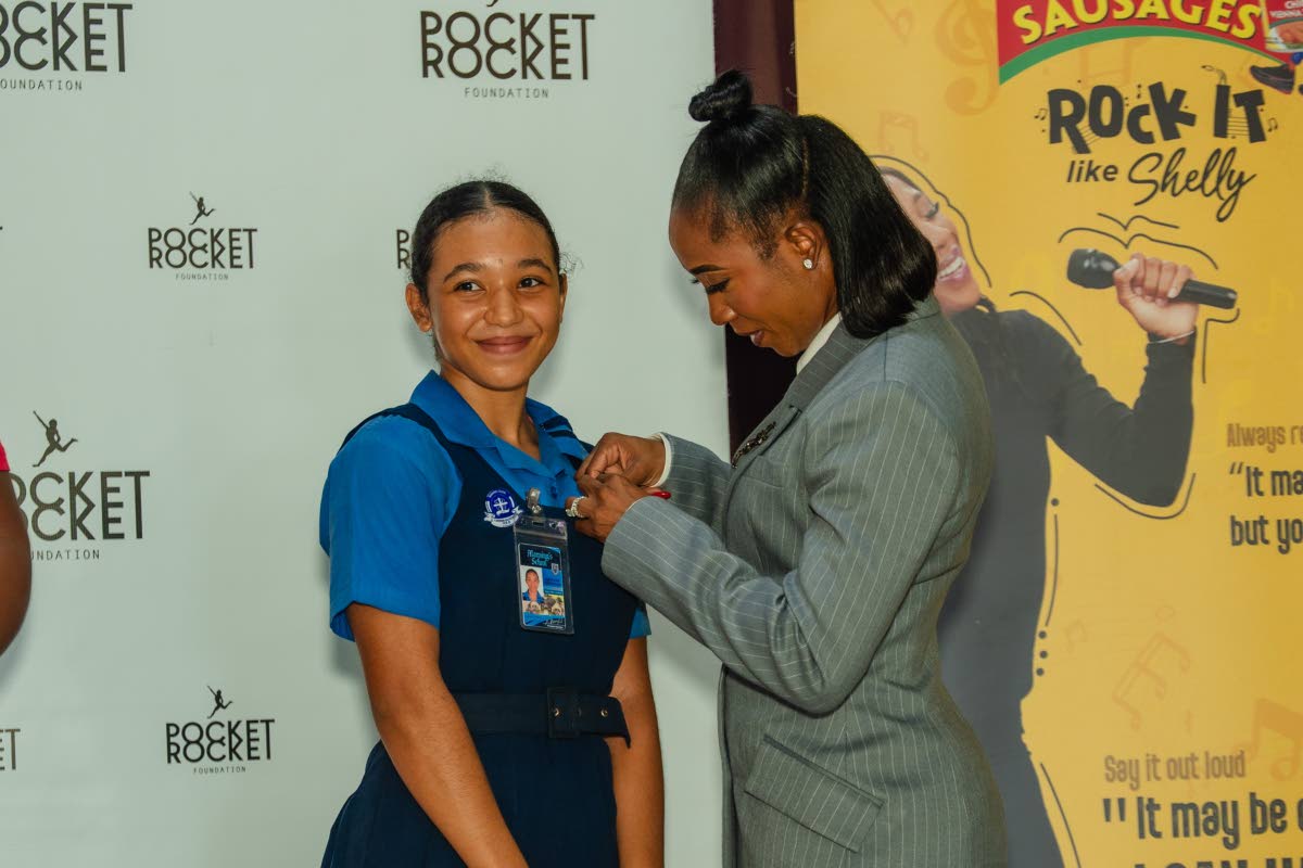 Shelly-Ann Fraser-Pryce, founder and chairwoman of the Pocket Rocket Foundation, pins 2026 scholar Jazmyne Wilkinson during the foundation’s annual scholarship awards at the Wolmer’s Girls’ School Hall on Thursday, September 24. Photo - Contributed Jamaica Gleaner, October 3, 2026.